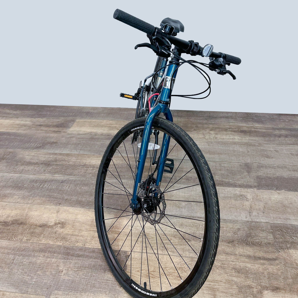 Front perspective of a Marin bike with visible handlebars and tires on wooden floor.