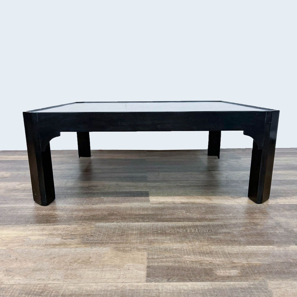 Dennis & Leen black coffee table with a modern, square design on wood flooring.