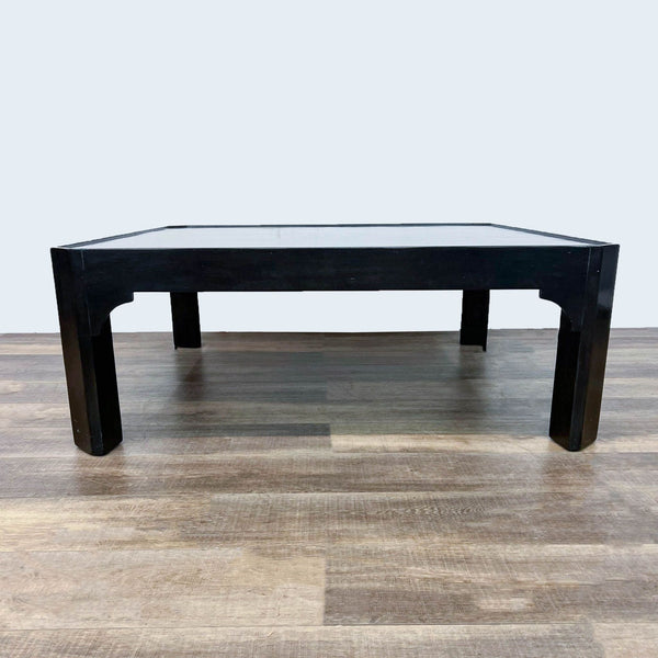 Dennis & Leen black coffee table with a modern, square design on wood flooring.