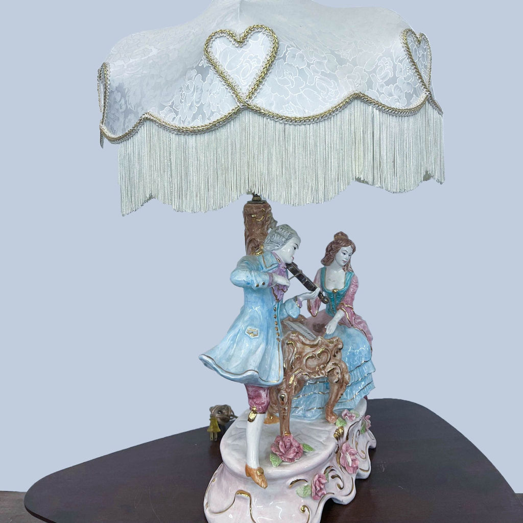 Vintage-style Reperch lamp featuring detailed musicians and a fringed shade.