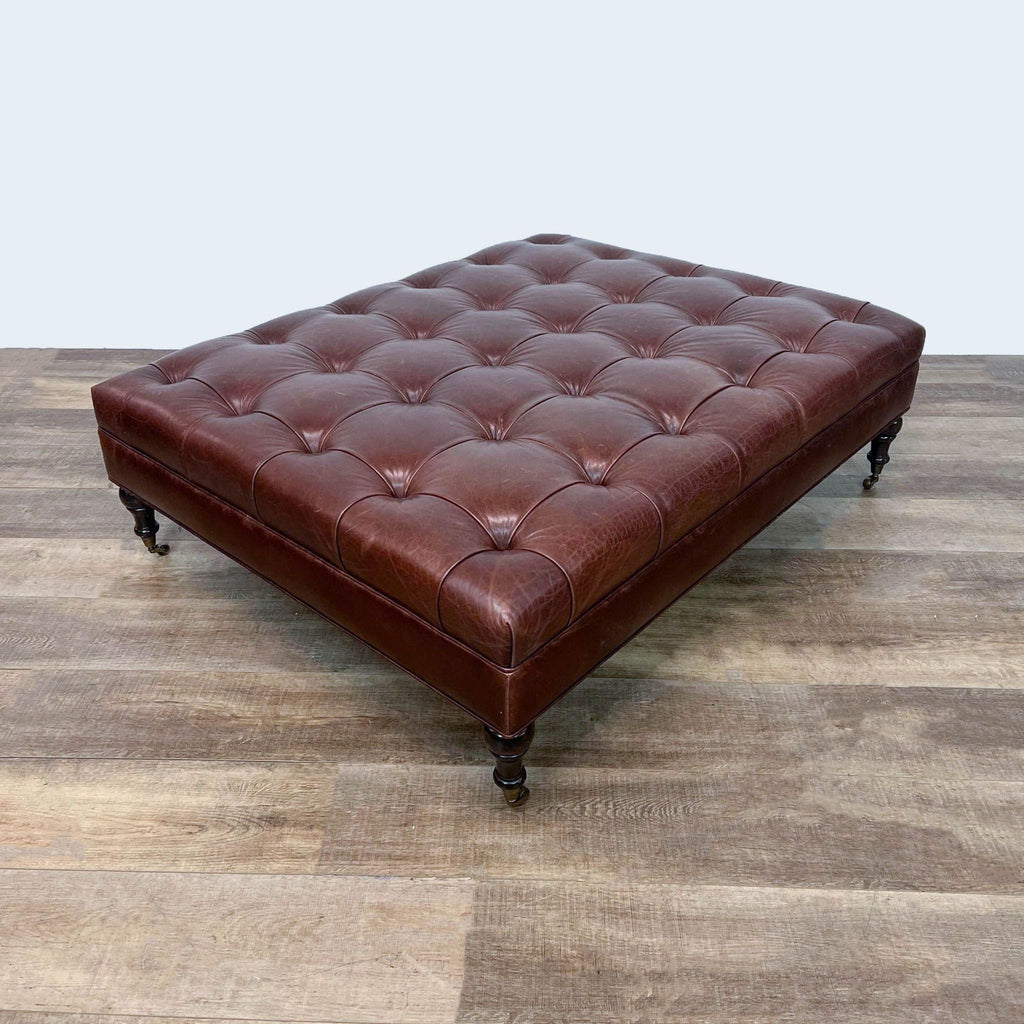 Large brown leather tufted ottoman with wooden legs and wheels.  