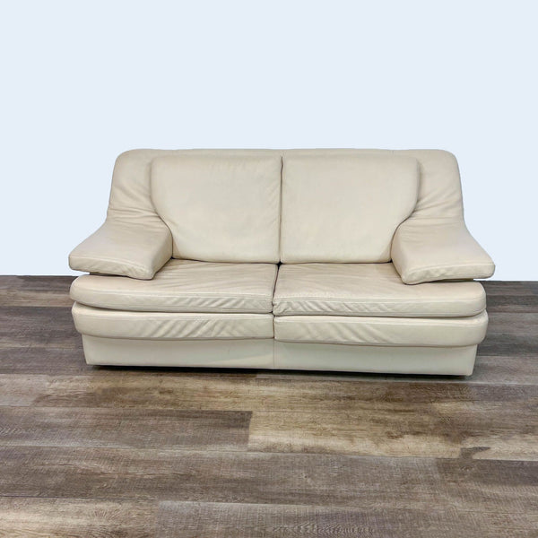 Ivory leather loveseat with high back and pillow top arms.
