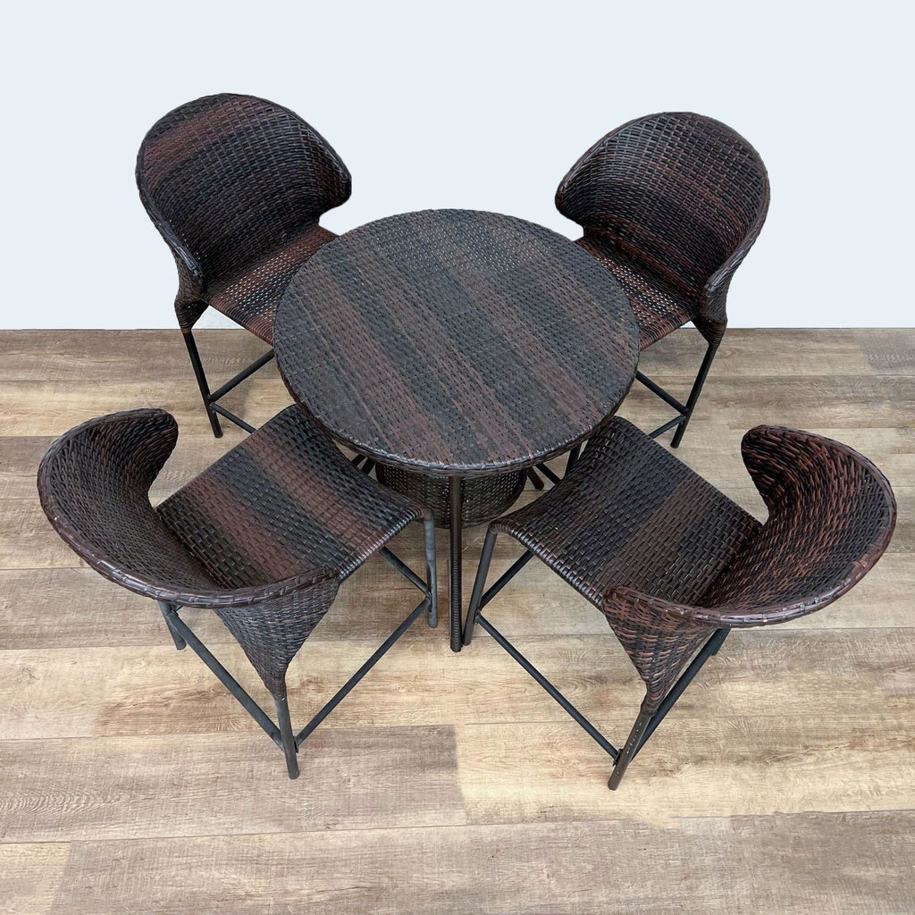 Reperch woven resin wicker table and four-chair set on metal frames.