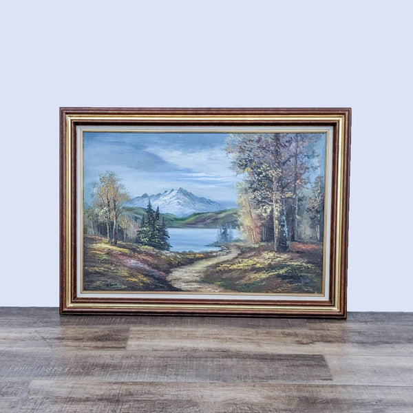 Framed autumn landscape painting with mountains in the background.