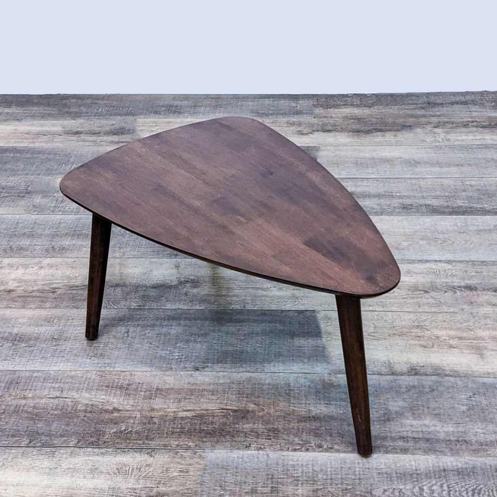 Elegant dark wood coffee table by Zuo Modern, featuring a unique triangular shape on three legs.
