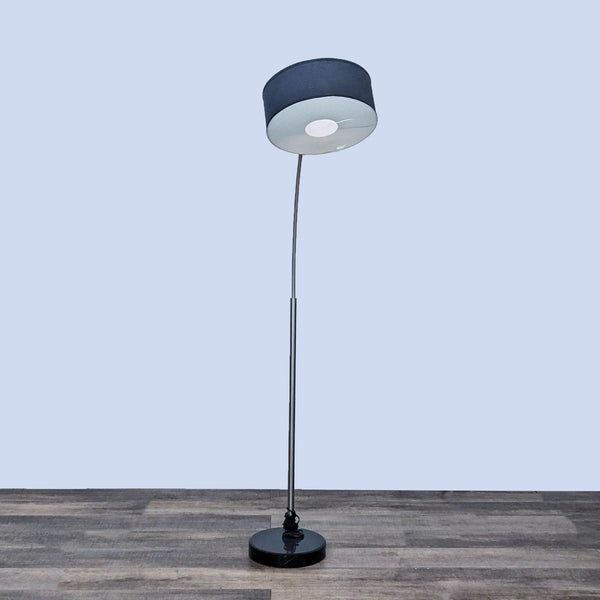 Reperch floor lamp with a sleek black shade and curving silver stand.