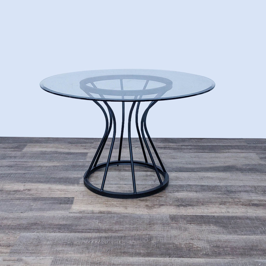 Modern Zurich dining table with bold metal base and round glass top by Armen Living.