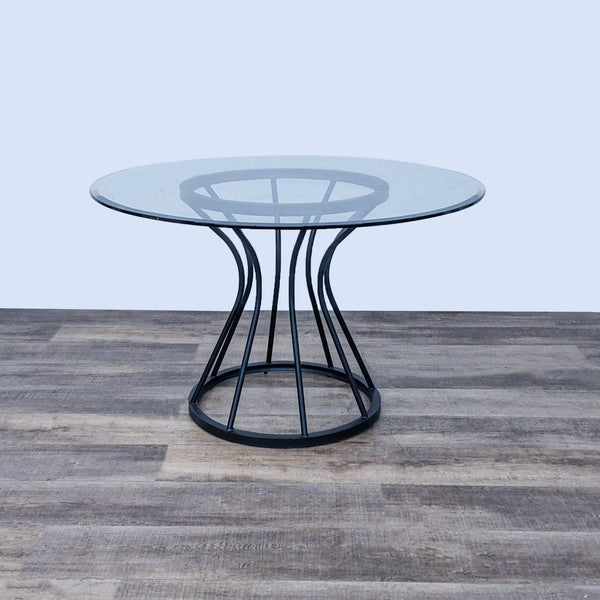 Modern Zurich dining table with bold metal base and round glass top by Armen Living.