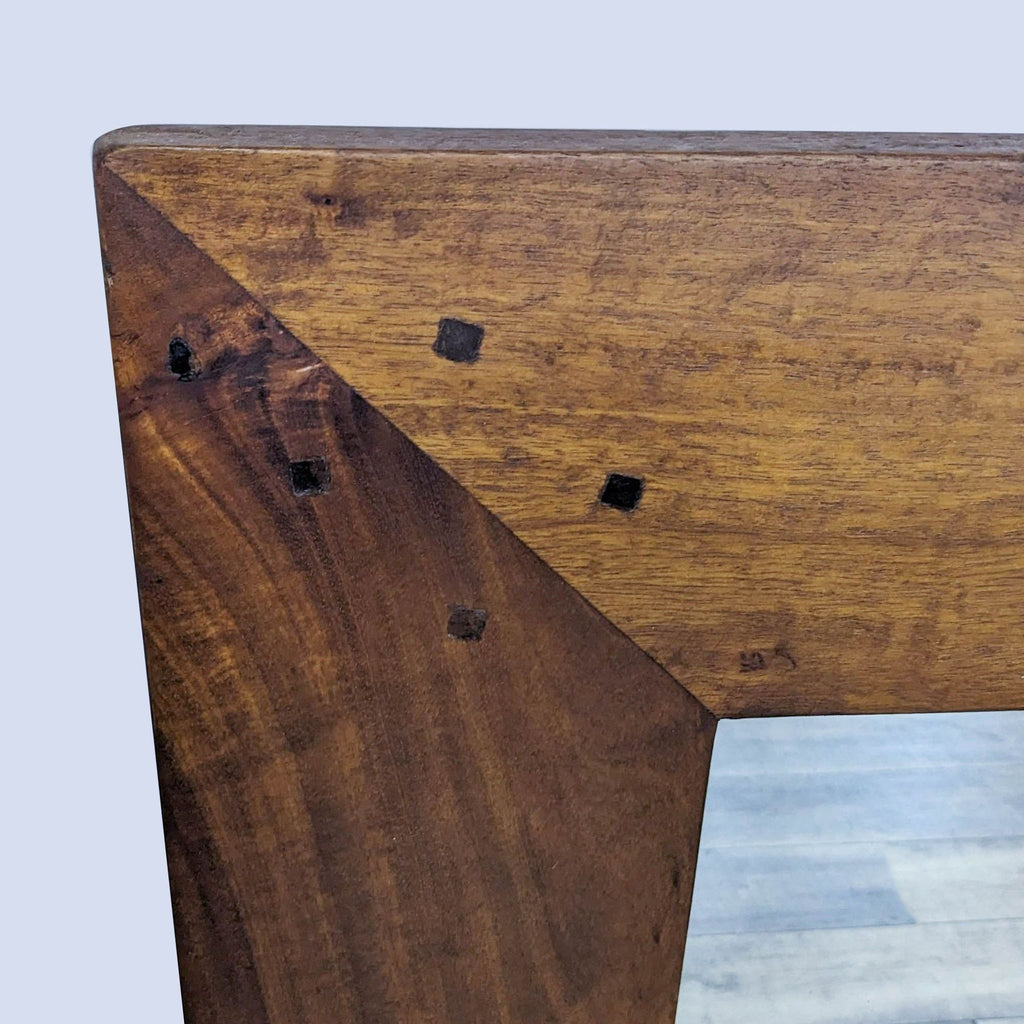 Close-up of the Reperch mirror's wooden corner with decorative detailing.
