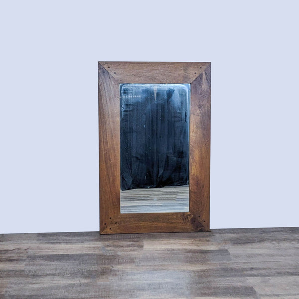 Reperch mirror with wide wooden frame, reflecting a dimly lit room.