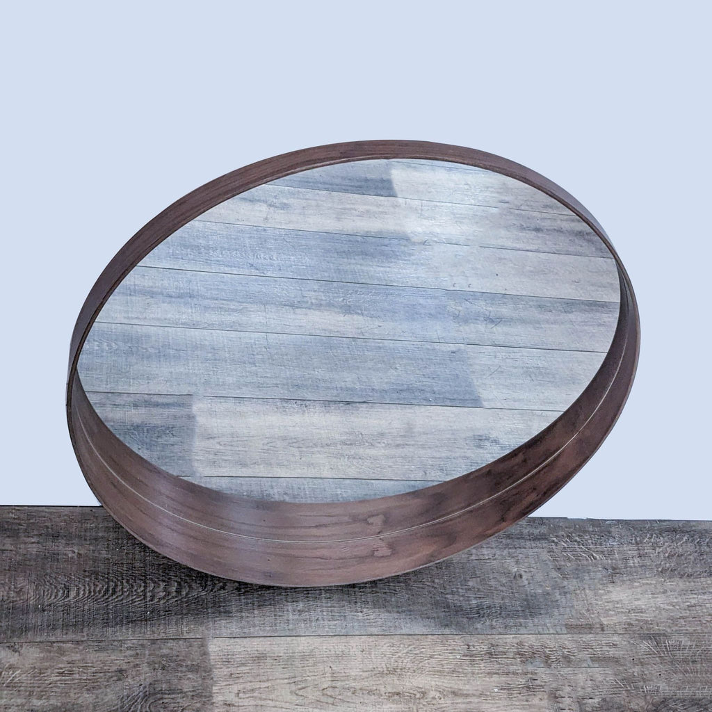 Round IKEA mirror with sleek walnut frame, reflecting curtains.