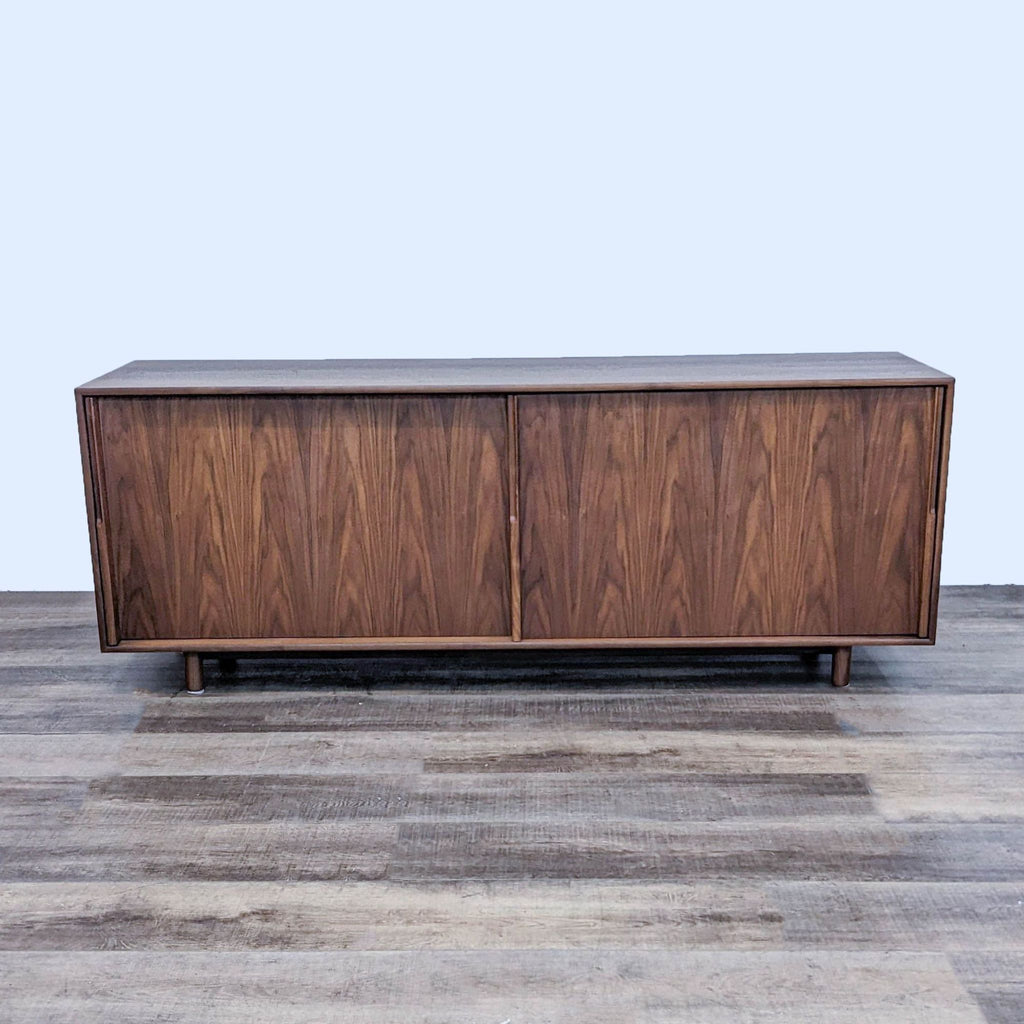 Mid-century modern walnut sideboard with closed doors and sleek design.