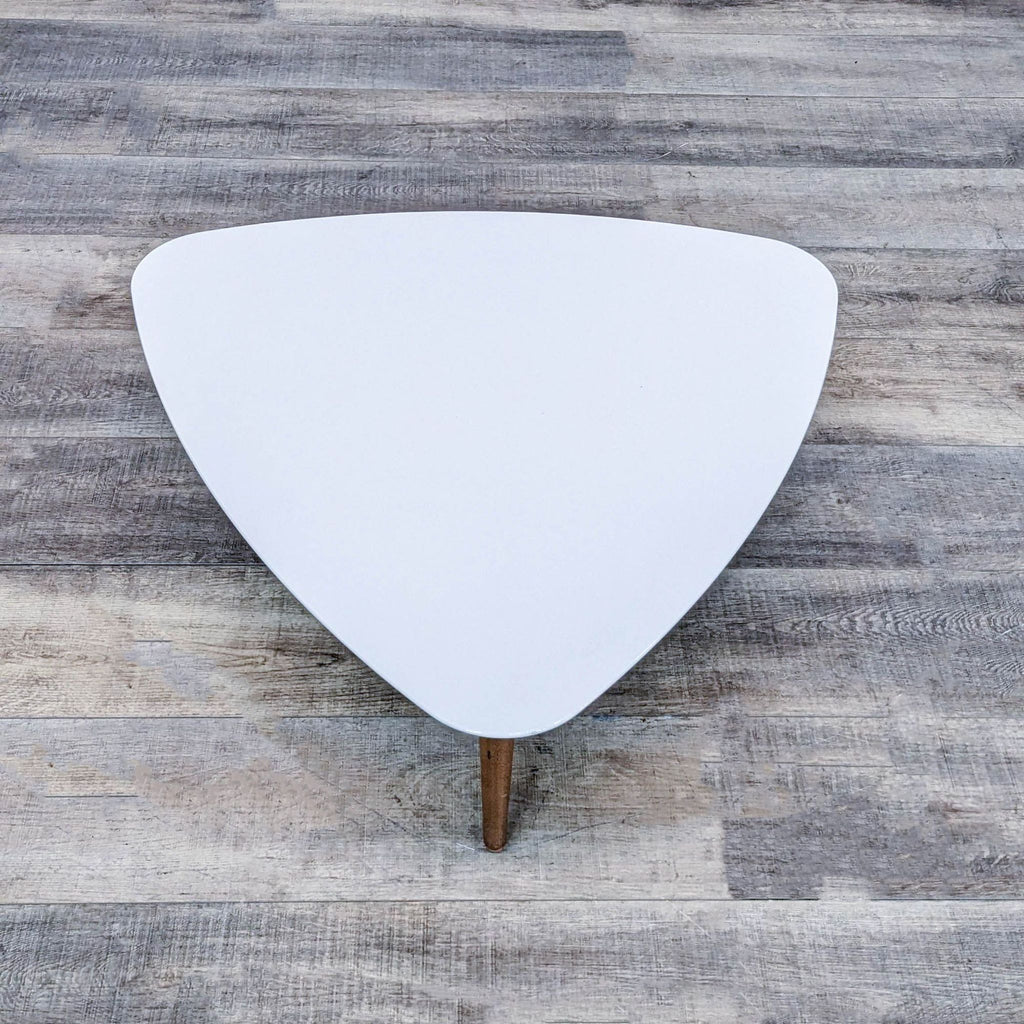 Modern Reperch coffee table, white top with three wooden legs.