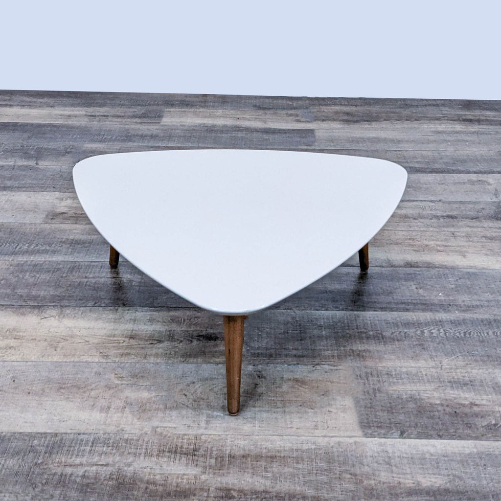 Reperch coffee table featuring a triangular white design and wooden legs.
