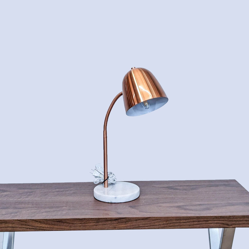 Copper lamp on a wooden table with a white marble base, brand Reperch.