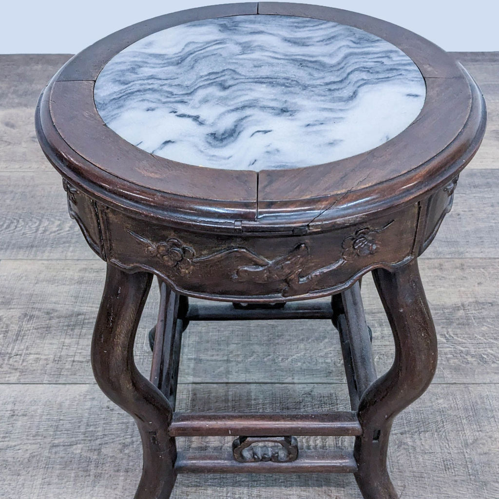 2. Close-up of Reperch console table, showing carved wood details and round marble inset tabletop.