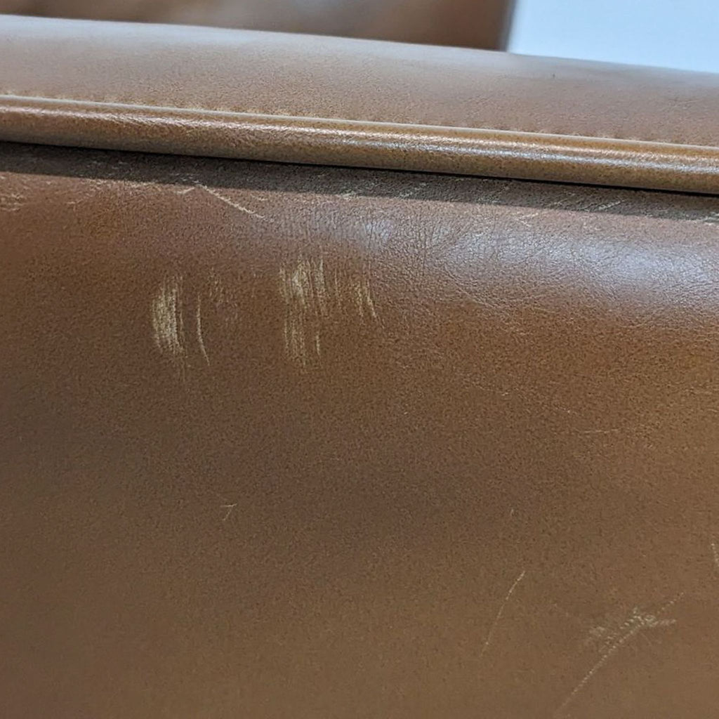 Close-up of brown faux leather upholstery highlighting texture and subtle markings.