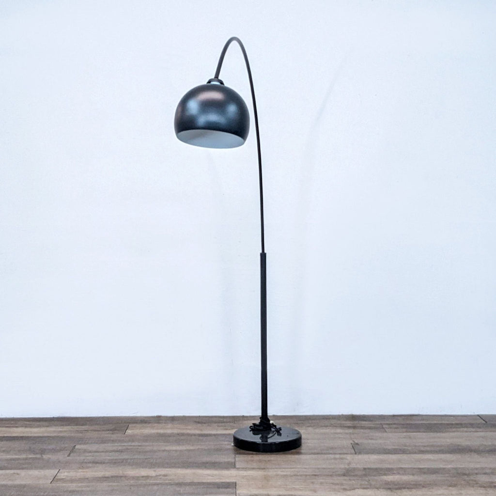Modern black floor lamp by Reperch with dome-shaped shade and a sturdy circular base.