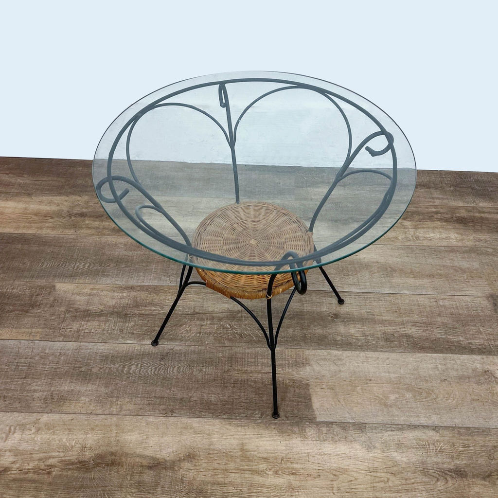 Glass-top bistro table with metal legs and wicker accent, viewed from above.
