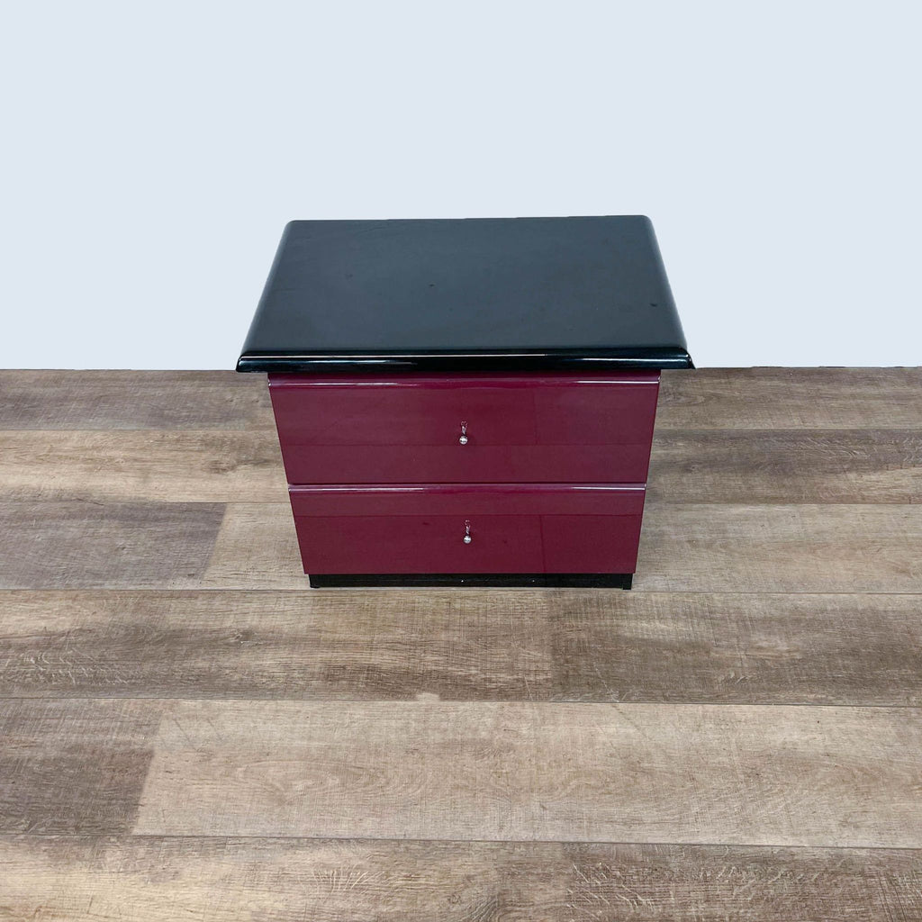 Top-down view of a sleek Millennium end table with glossy maroon drawers, standing on wood floors.