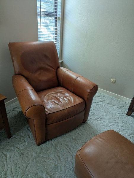 1. Ethan Allen brown leather lounge chair with rolled arms placed by a window on a textured carpet floor.  