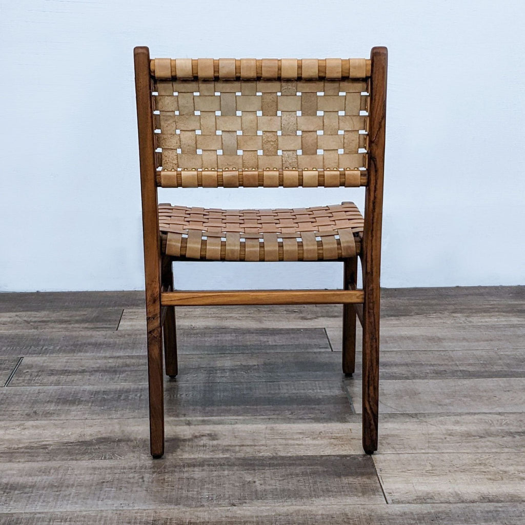 Back view of a teak dining chair with a woven leather design, highlighting its craftsmanship.