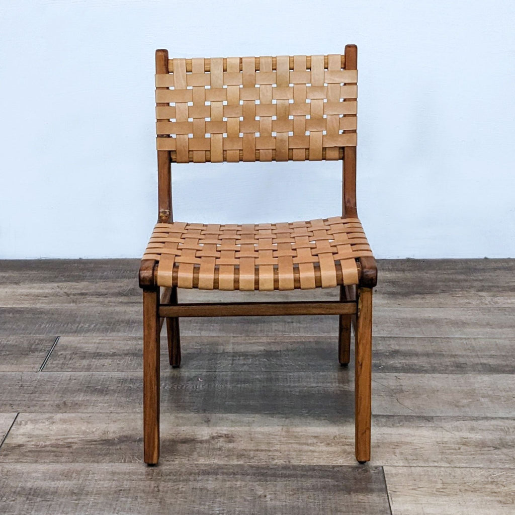 Front view of a solid teak dining chair with woven leather straps by Teak Me Home.