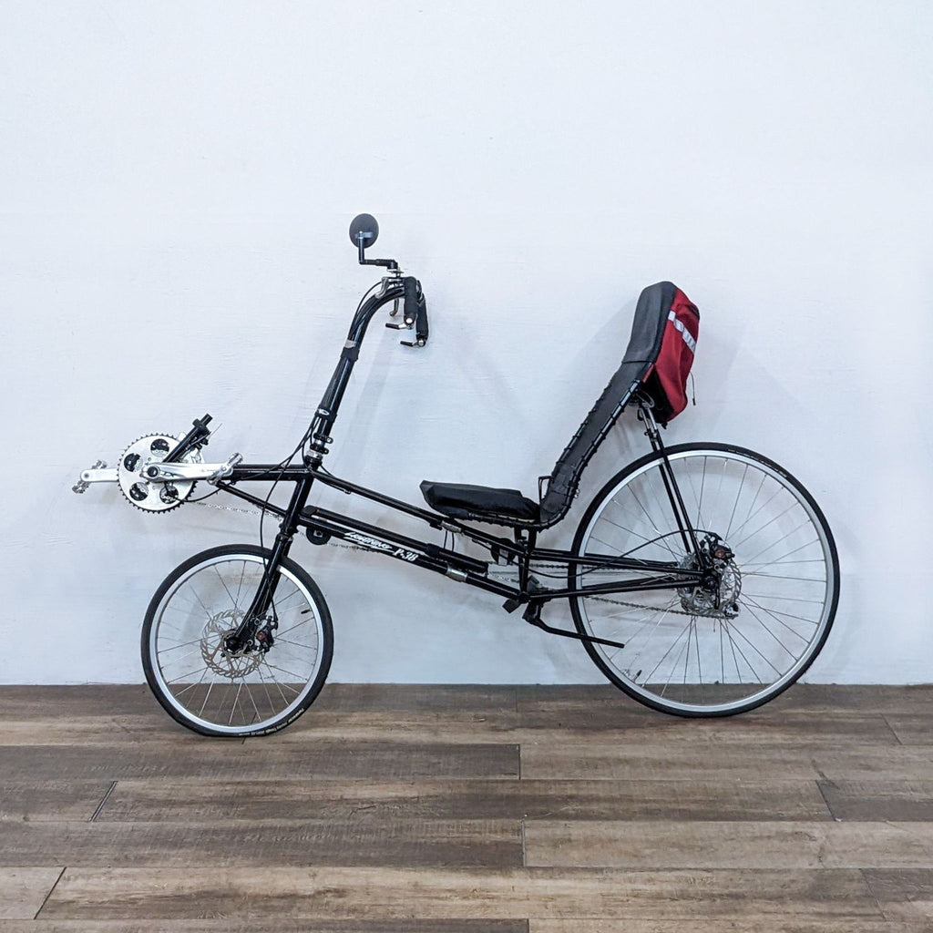 Side view of a Lightning recumbent bike against a white wall.