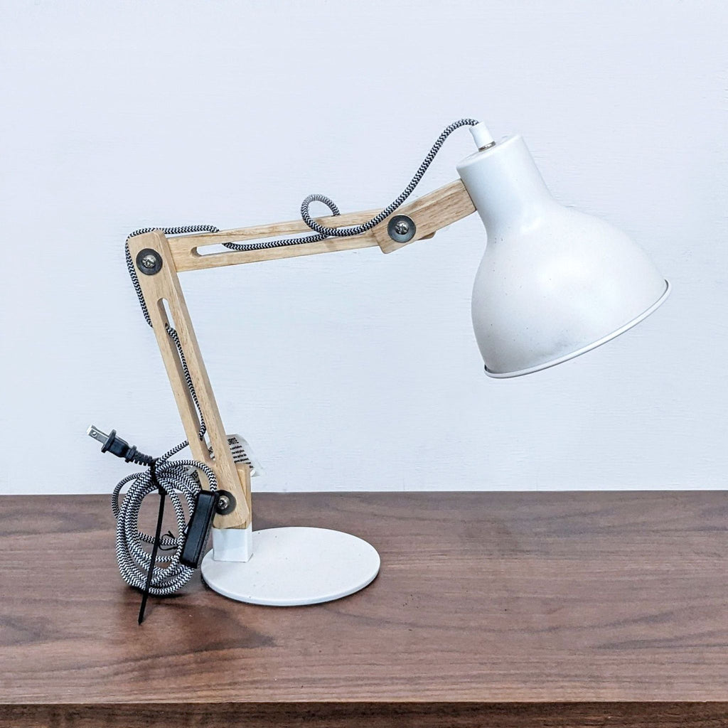 Wooden-angle desk lamp with white shade on a wooden surface.
