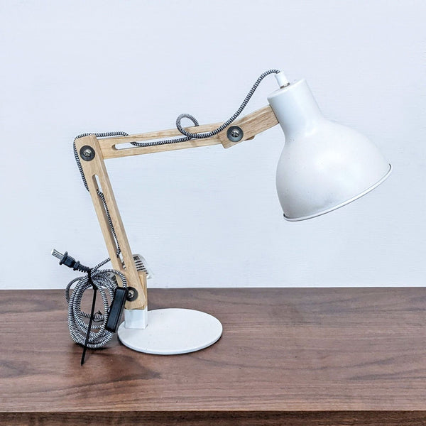 Wooden-angle desk lamp with white shade on a wooden surface.