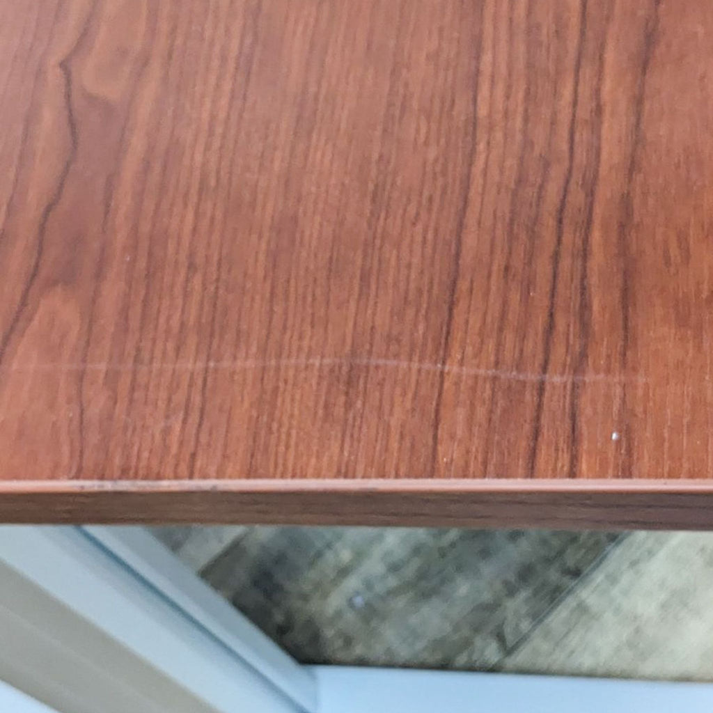 Close-up of the desk's wood finish surface, showing its texture and natural grain details.