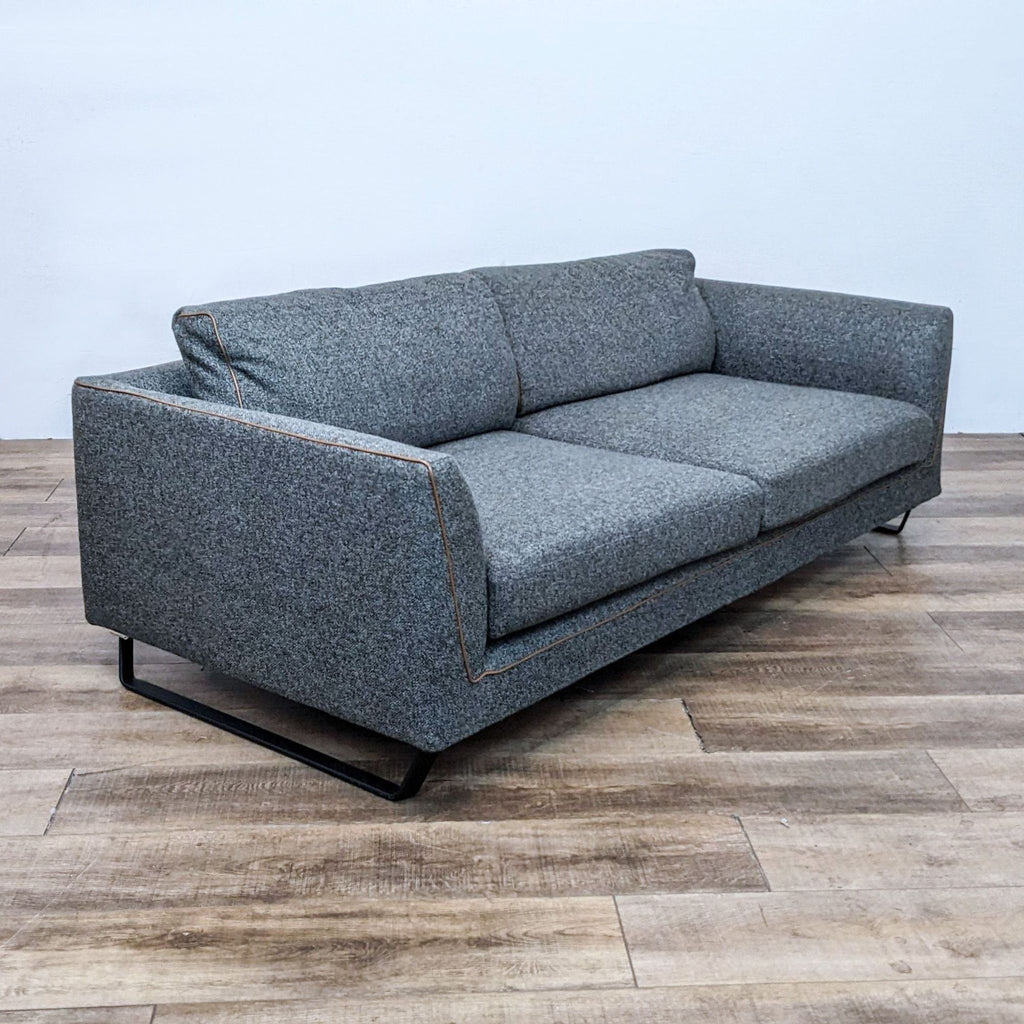 Scandinavian style 3-seat sofa with dark metal frame and contrast leather piping. 