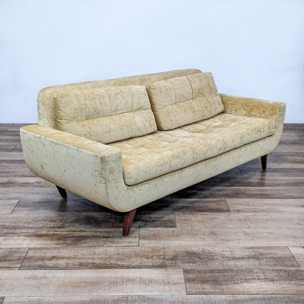 Beige chenille 3-seat sofa with tufted cushions and tapered feet on wooden floor.