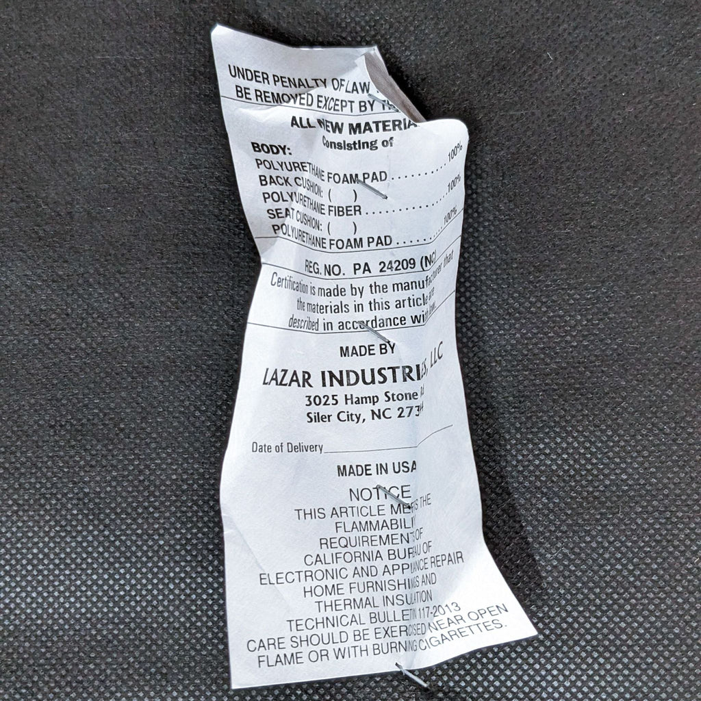 Tag with manufacturing details and material information for a sofa, on a dark fabric background.