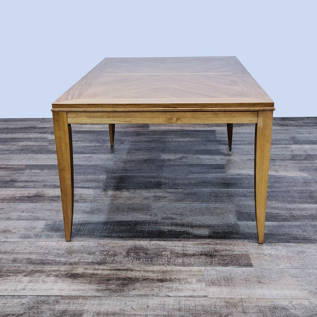 Wooden dining table featuring framed herringbone design and extension leafs.