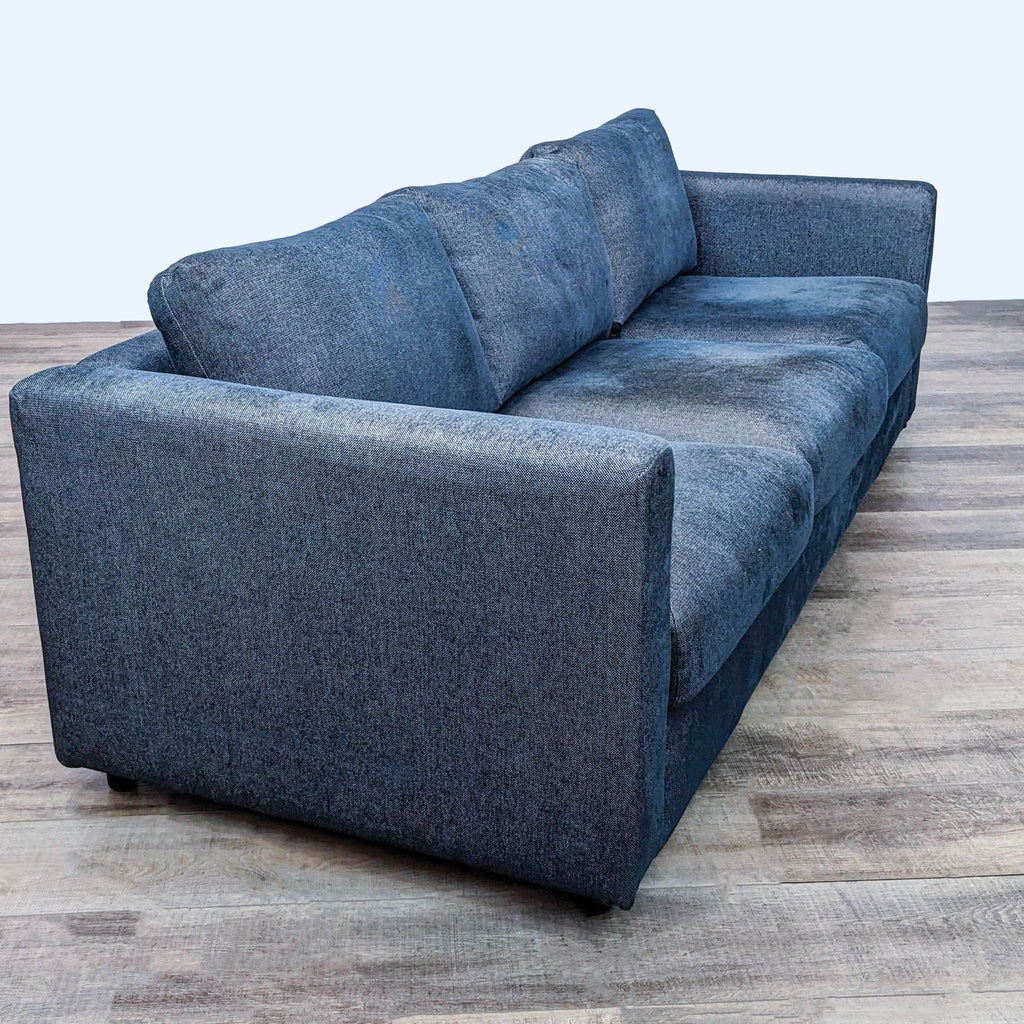 Side view of a blue three-seat Ikea sofa showcasing its square arms and modern design.
