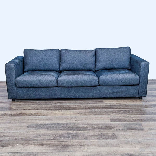 Eight-foot blue sofa with square arms and clean lines, placed on a wooden floor.