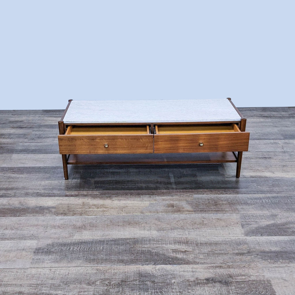 Wooden coffee table by West Elm with open drawers, showcasing marble top and bottom storage shelf.