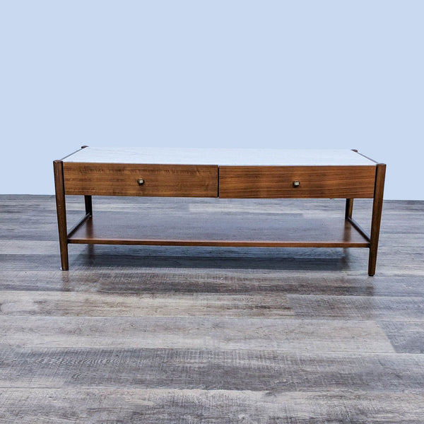 West Elm coffee table with wood finish and marble top, featuring two drawers and a lower shelf.