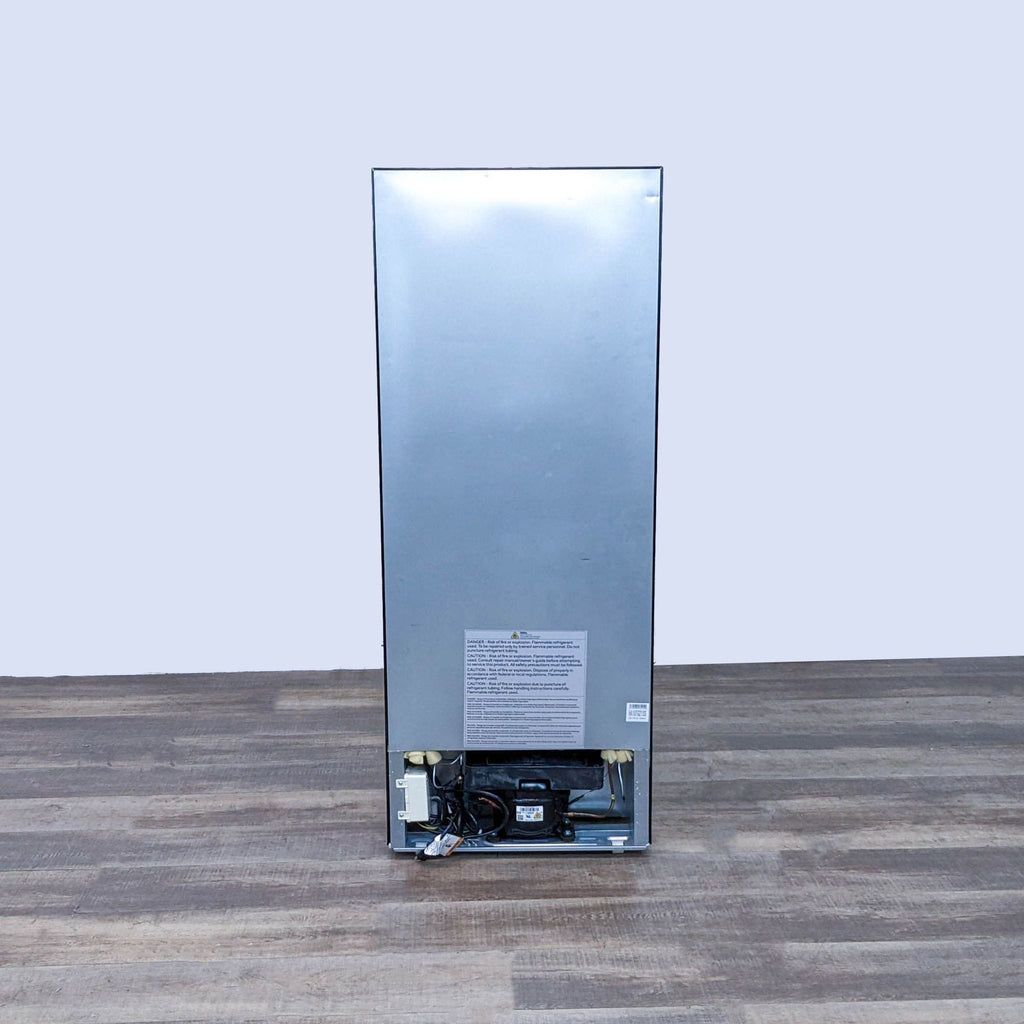 Back view of a Haier refrigerator showing the compressor and specifications.