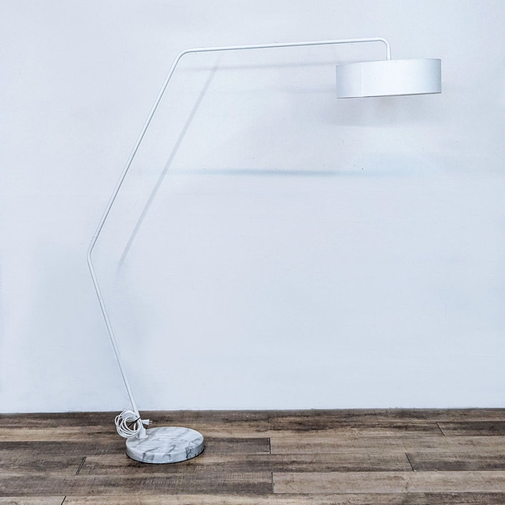 Modern white floor lamp with angled stand and marble base.  
