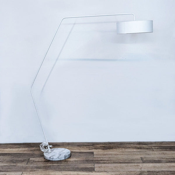Modern white floor lamp with angled stand and marble base.  
