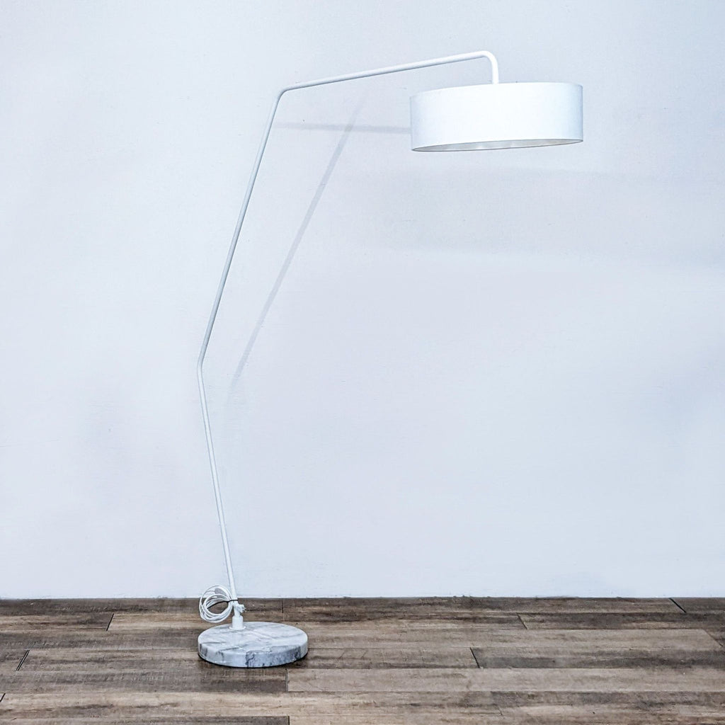 Contemporary white floor lamp with a bent design and sturdy marble base.