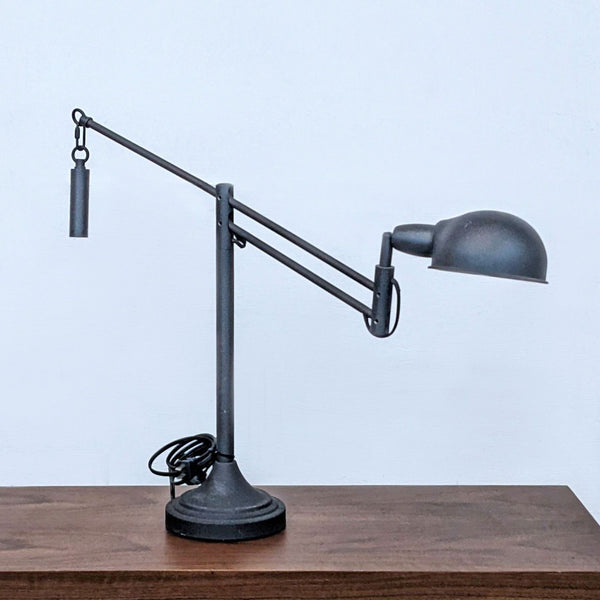 Reperch lighting fixture with adjustable arm on a wooden surface.