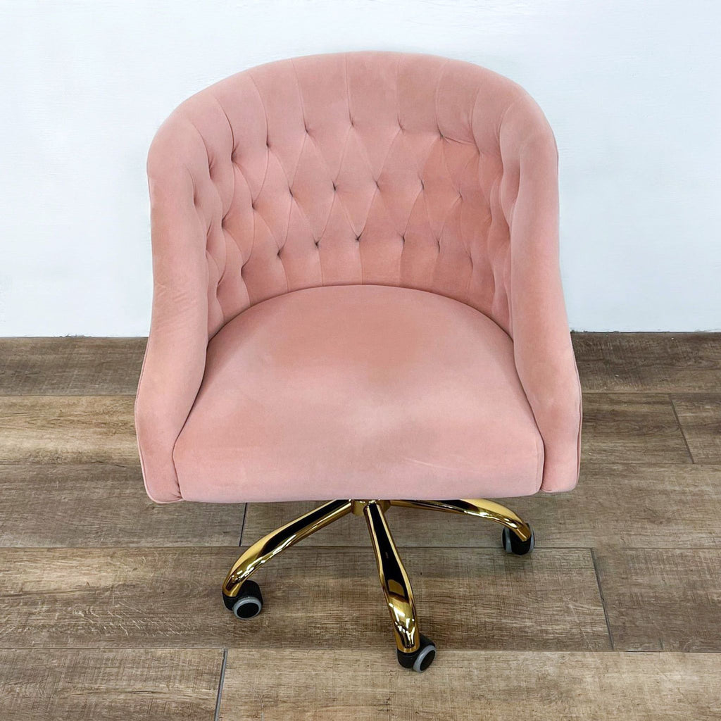 Rounded back office chair with gold-finish metal legs and smooth casters.