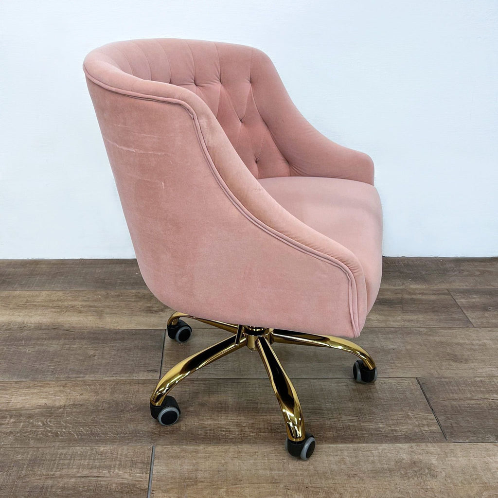 Modified wingback chair in pink velvet with sloped arms and button tufting.