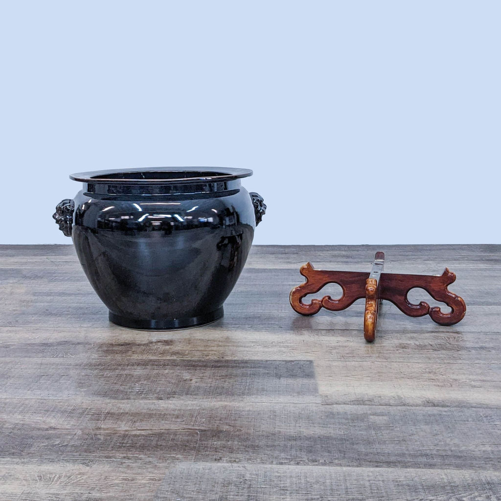 Reperch vase and separate wooden stand on a wooden floor.