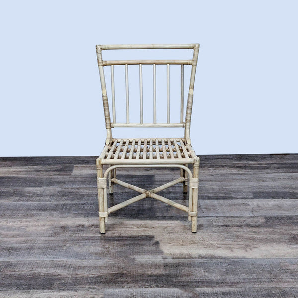 Pottery Barn side chair with sleek rattan design, perfect for dining areas.