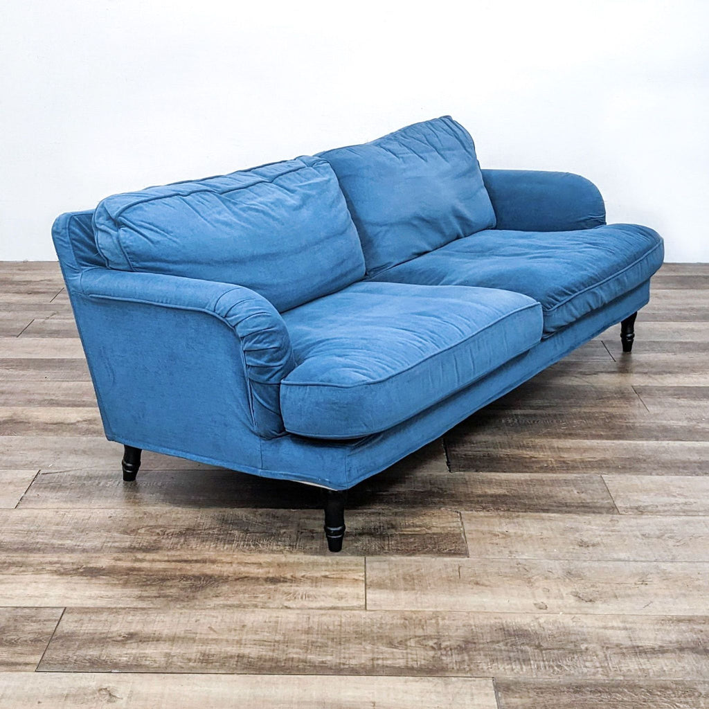 Three-seat blue sofa with soft cushions and rounded arms.  