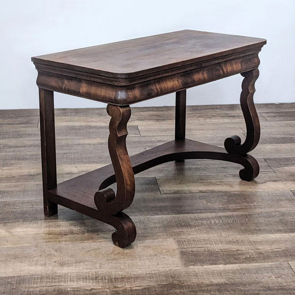 Mahogany writing desk with scrolled legs and natural wood grain.
